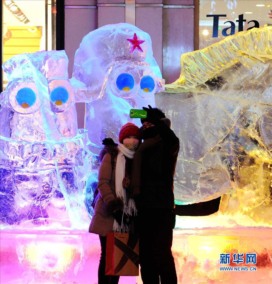 1月14日,兩位游客在哈爾濱市中央大街的一處冰雕前合影。 1月14日,兩位游客在哈爾濱市中央大街的一處冰雕前合影。