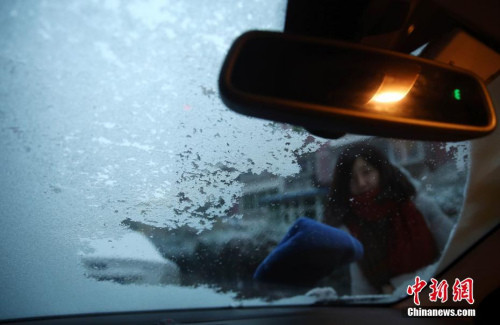 11月21日，露天停放的機動車被冰雪覆蓋，車主出行前除冰。當日，北京降下今冬初雪，前半夜的冰雨將氣溫拉至冰點以下，而后雨轉為雪。<a target='_blank'  _fcksavedurl='http://www.chinanews.com/'></table>中新社</a>記者 楊可佳 攝