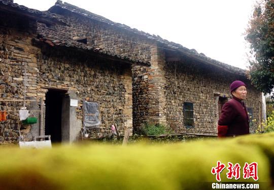 一位老人走出其居住的石頭屋。石頭屋多建在河畔,取材自河中或山間石塊,以石為墻,以木為梁,冬暖夏涼。3月29日拍攝。 王昊陽 攝