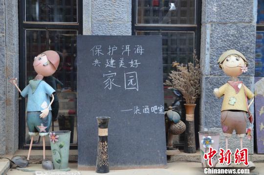洱海邊一酒吧打出“保護洱海,共建美好家園”字樣,支持洱海保護行動。 繆超 攝