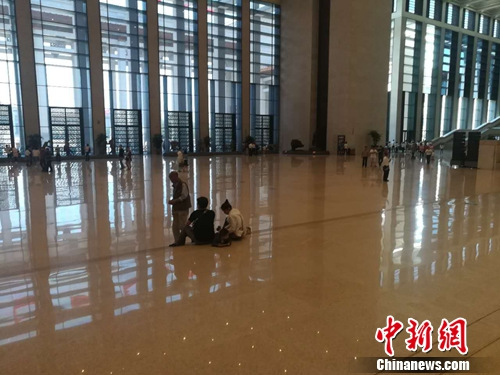 16日,兩名參觀者坐在國博內大廳的臺階上。上官云 攝