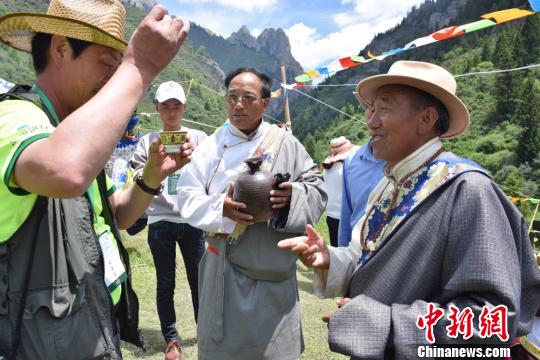 圖為當地村里老人向游客敬獻青稞酒。 南如卓瑪 攝