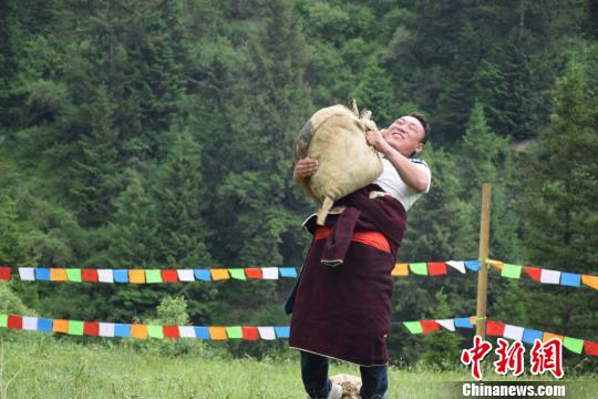 圖為當地男兒舉重物比力氣。 南如卓瑪 攝