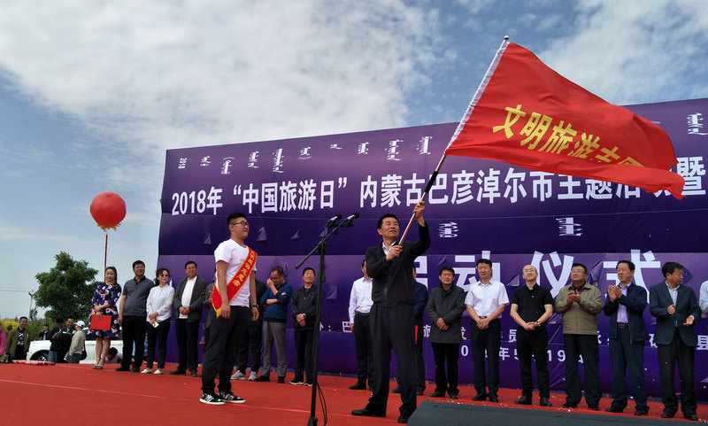巴彥淖爾市旅游發展委員會主任徐峰為文明旅游志愿者授旗 李慧 攝
